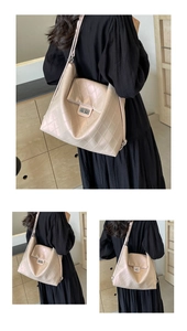 Close-up of champagne gold quilted tote bag with metallic luster and silver turn-lock