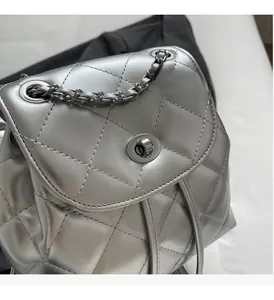 Close-up of silver quilted backpack featuring a metallic finish and turn-lock closure