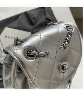 Detail of silver quilted leather bag showing hardware chain and metallic texture