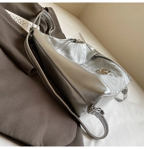 Dettaglio borsa tote argento con trama marmorea su blazer marrone per uno stile da ufficio