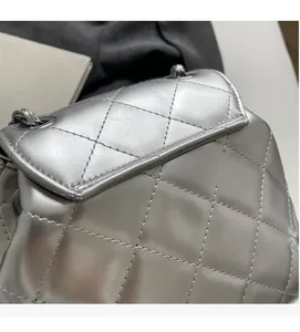 Detail of silver quilted texture and metallic finish on a stylish chain backpack