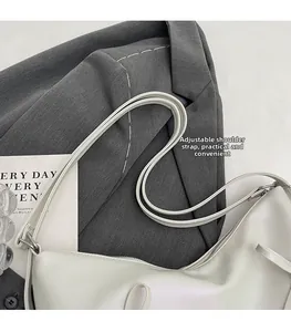 Vue détaillée de la bandoulière réglable avec boucle argentée sur un sac cabas blanc