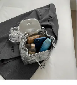 Silver quilted bucket bag with spacious interior showing phone and daily essentials
