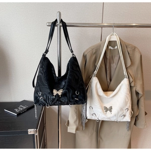 Detail of black and white hobo bags with marble texture, butterfly buckle and silver chains
