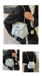 Detail view of light blue quilted mini backpack with chain straps and metal twist lock