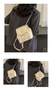 Detail of cream quilted leather backpack showing chain straps and silver twist lock closure