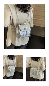 Detail of silver quilted backpack with chain straps and metallic finish texture