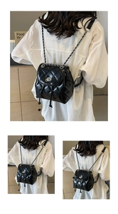 Detail view of quilted chain backpack with silver twist lock and drawstring closure