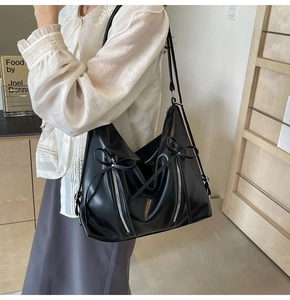 Détail du sac cabas noir en cuir PU avec fermetures éclair argentées et nœuds élégants