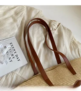 Detailed shot of handmade straw tote texture with brown leather strap in lifestyle setting