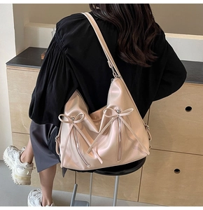 Détails du sac fourre-tout doré champagne avec nœuds décoratifs et fermetures métalliques