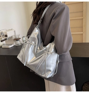Détail du sac cabas argenté métallisé avec nœud décoratif et fermeture éclair
