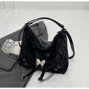 Detail of black marble textured bag with silver butterfly buckle and metal chain strap