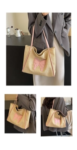 Detail of a large woven tote bag with pink leather butterfly patch and long shoulder straps