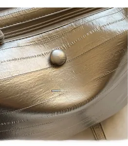 Detailed close-up of champagne gold small square bag with quilted texture and metal buckle