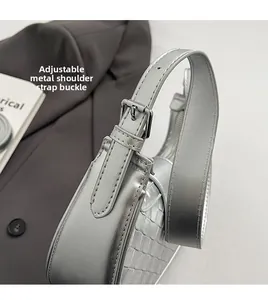 Detailed close-up of adjustable silver metal buckle and woven texture on handbag