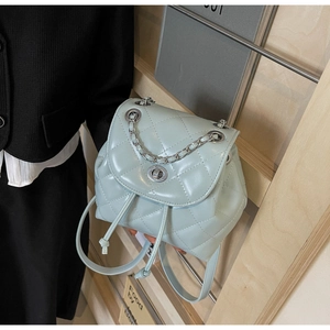 Detail of light blue quilted PU leather mini backpack with silver metal twist lock and chain