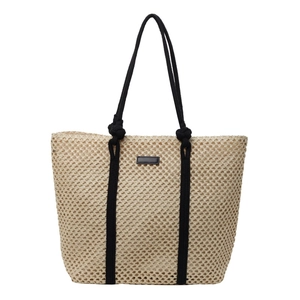 Minimalist straw tote bag with black rope handles and openwork mesh weave for summer