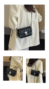 Close-up of a black quilted crossbody bag with silver chain strap and metallic twist lock