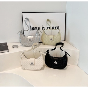 Detail view of woven half-moon bags in silver, beige, and black with metal buckle
