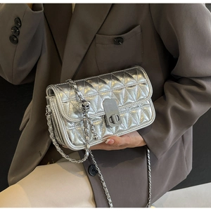 Detail of silver metallic quilted crossbody bag with chain strap and triangle pattern