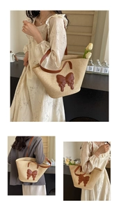Detail of straw woven tote bag featuring a brown leather bow and long shoulder straps
