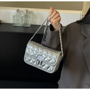 Detail of silver metallic quilted bag with chain strap and rectangular turn-lock closure