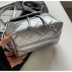Detailed macro view of silver quilted bucket bag with metallic faux leather texture