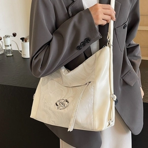 Elegante borsa tote crema con pannello effetto marmo e logo in metallo indossata