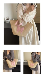 Detail of summer straw tote bag with pink leather handles and bow decoration