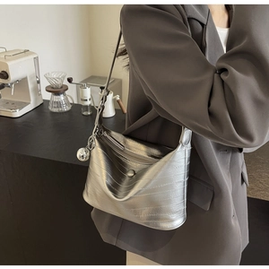 Detail of silver crocodile texture Hobo bag with metallic ball charm in a cafe