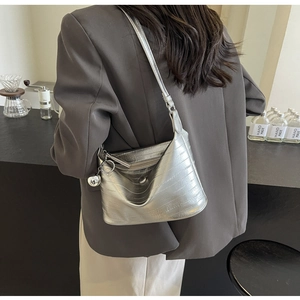 Silver metallic crossbody bag with crocodile pattern and decorative silver ball charm