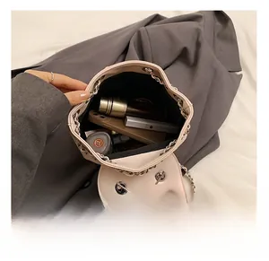 Detail view of pink bucket bag interior holding a phone, lipstick and cosmetics