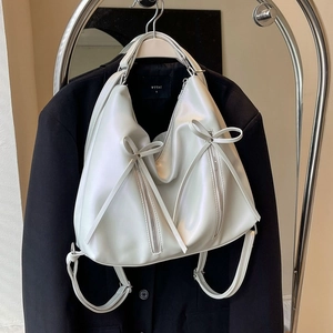 Sac à dos blanc nacré avec nœud ruban et double fermeture éclair sur fond noir