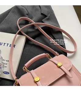 Detail of light pink PU leather bag with adjustable strap and golden metal buckles