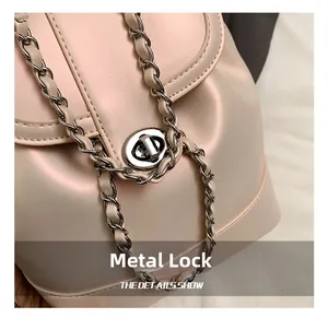 Detail of silver twist-lock closure and leather-woven chain on pearl pink backpack