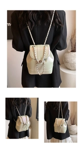 Detail of light green pearlescent leather backpack with silver chain and metal lock
