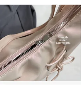 Detail of smooth silver zipper closure on light pink pearlescent commuter tote bag