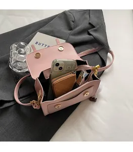 Interior detail of pink leather crossbody bag showing dual magnetic snap and storage space