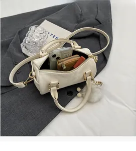 Interior view showing large capacity of the off-white Boston bag with daily items
