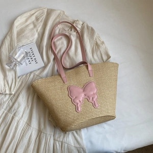 Large beige woven straw tote bag with pink leather butterfly and shoulder strap
