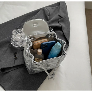 Quilted silver backpack showing spacious interior for wallet, phone and cosmetics