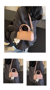 Detail of pink Boston bag with embossed textures and a cute white plush sheep charm