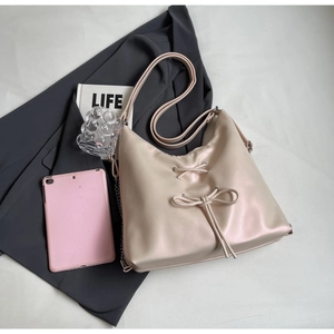 Detail of minimalist beige pink tote bag featuring a decorative bow tie and drawstring