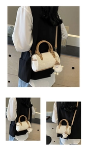 Detail of cream Boston bag with brown handles and a cute white sheep charm