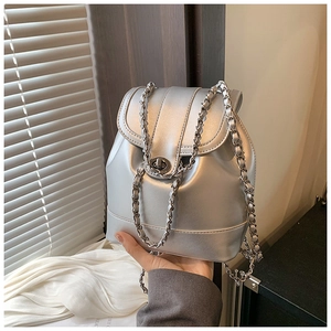 Detail of silver metallic mini backpack featuring a metal twist lock and chain strap