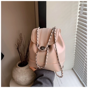 Detail of light pink mini backpack featuring metal chain straps and twist lock closure