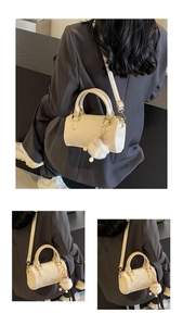 Detail of cream white Boston bag with leather handles and cute plush charm accessory