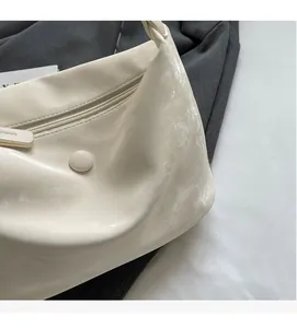 Detailed macro view of cream-white PU leather texture and zipper on the shoulder bag