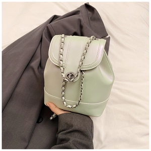 Detail of mint green PU leather bucket backpack with silver twist lock and chain strap